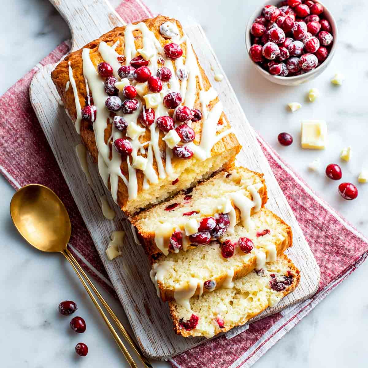 Cranberry white chocolate chip cake bread drizzled with glaze.