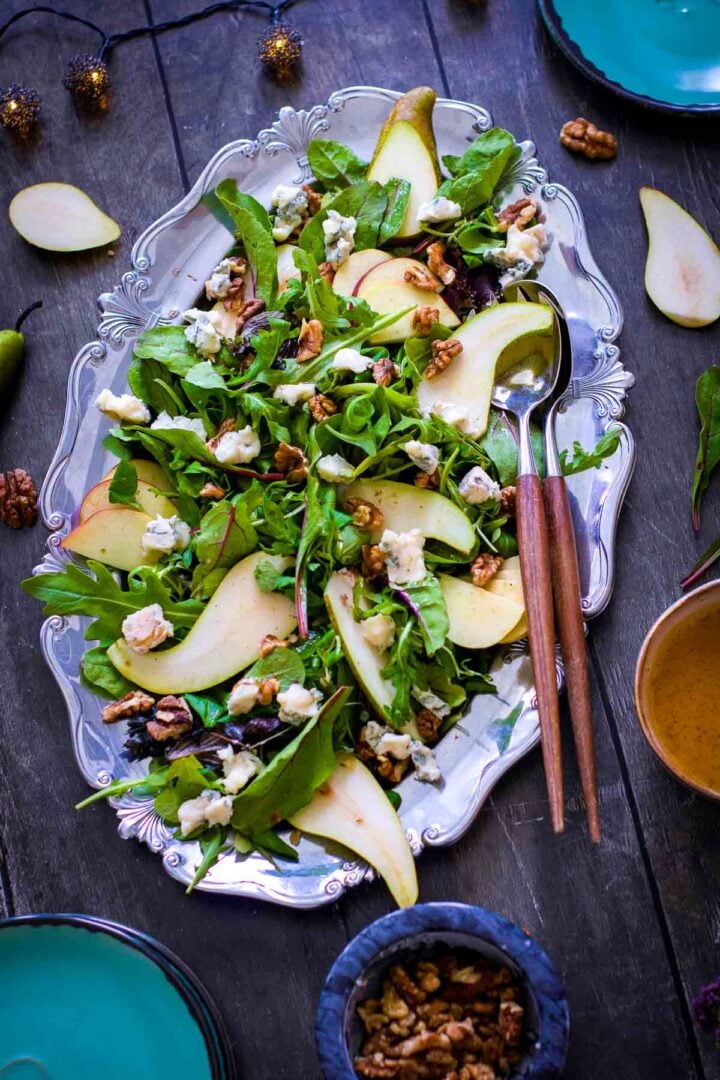 Overhead view of pear and apple harvest salad with walnuts and crumbled blue cheese.