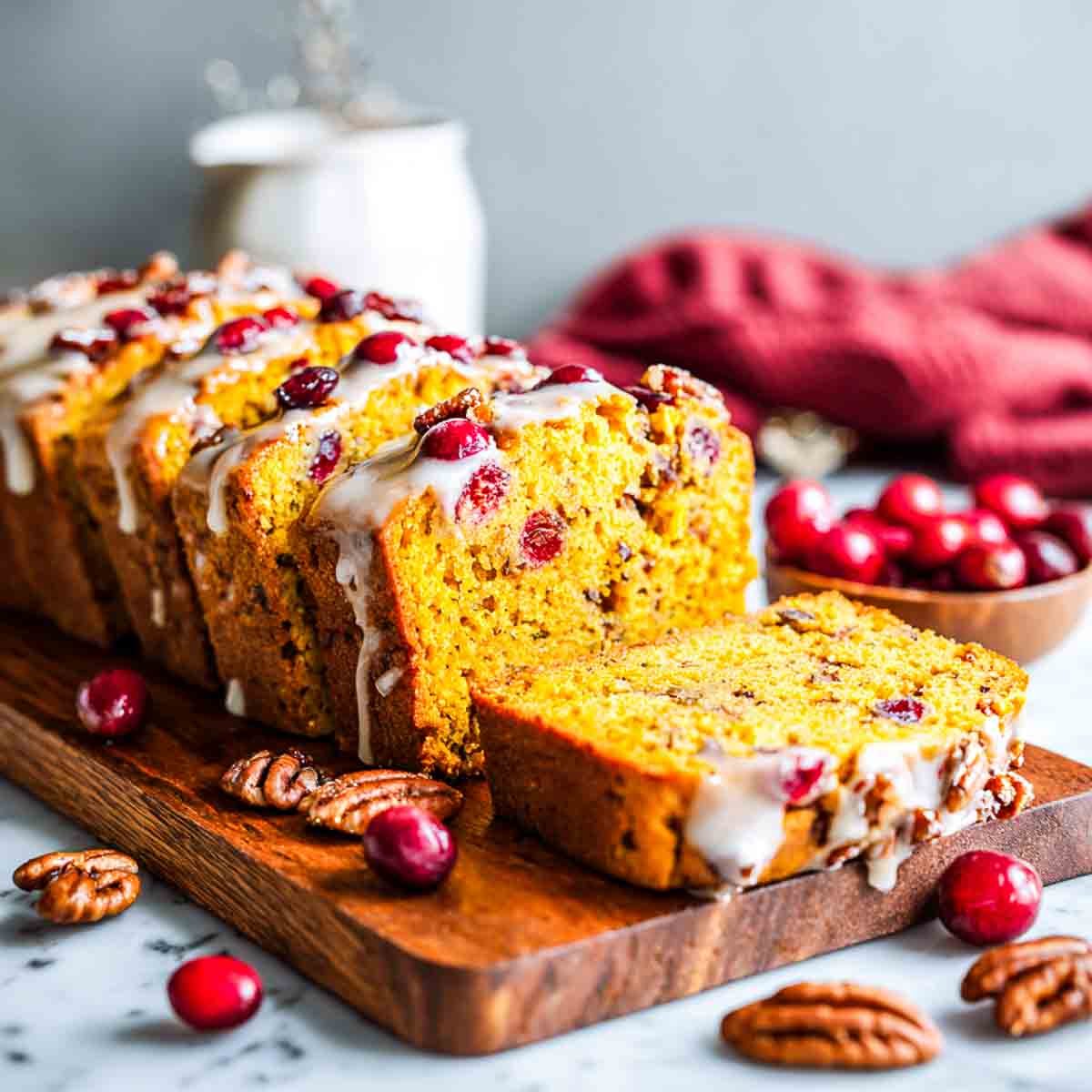 Pumpkin cranberry bread sliced on a board.