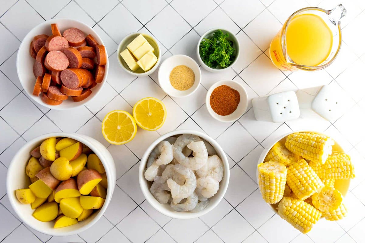 Instant Pot shrimp boil ingredients including shrimp, sausage, corn, potatoes, and spices.