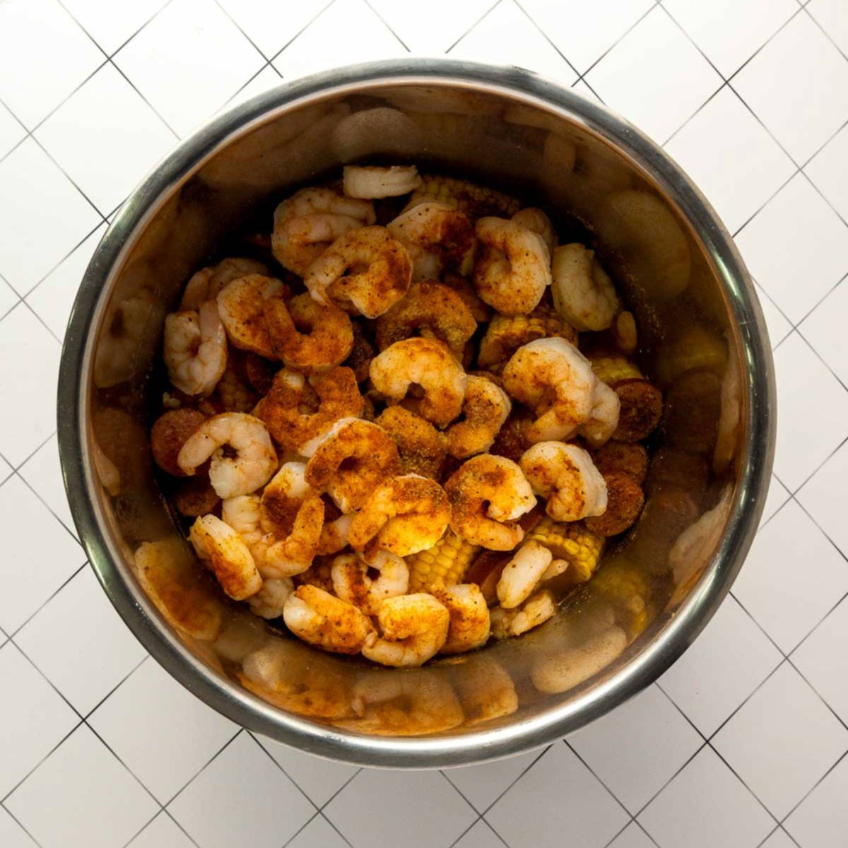 Shrimp cooking with sausage, corn, and potatoes in Instant Pot.