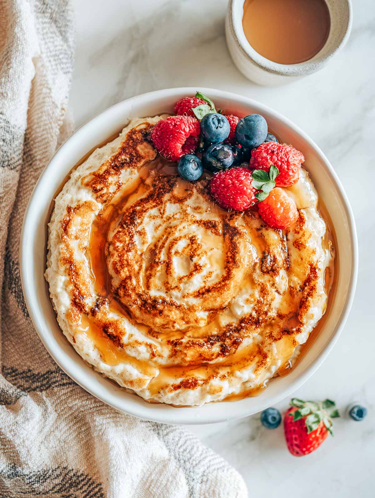 Fluffy cottage cheese oatmeal pancake bowl with maple drizzle and fresh berries.