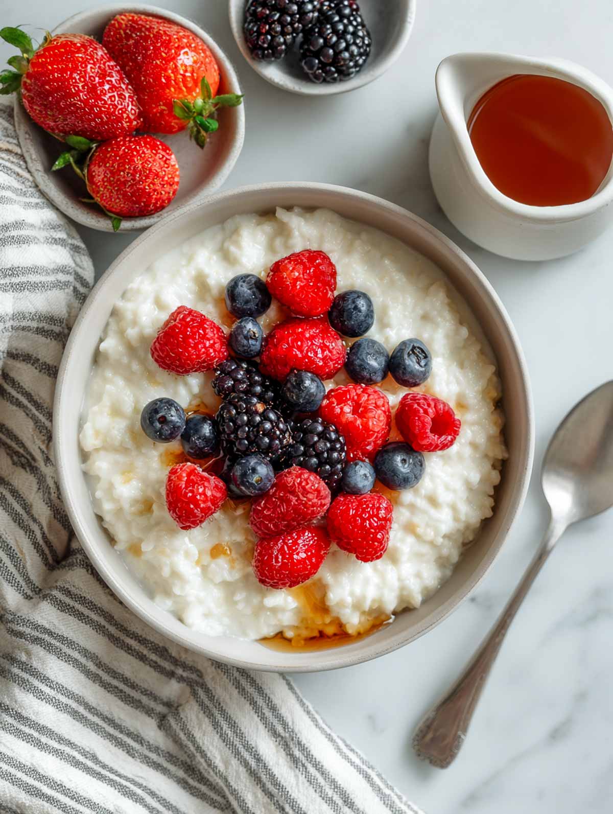 Creamy cottage cheese oatmeal topped with mixed berries and maple drizzle.