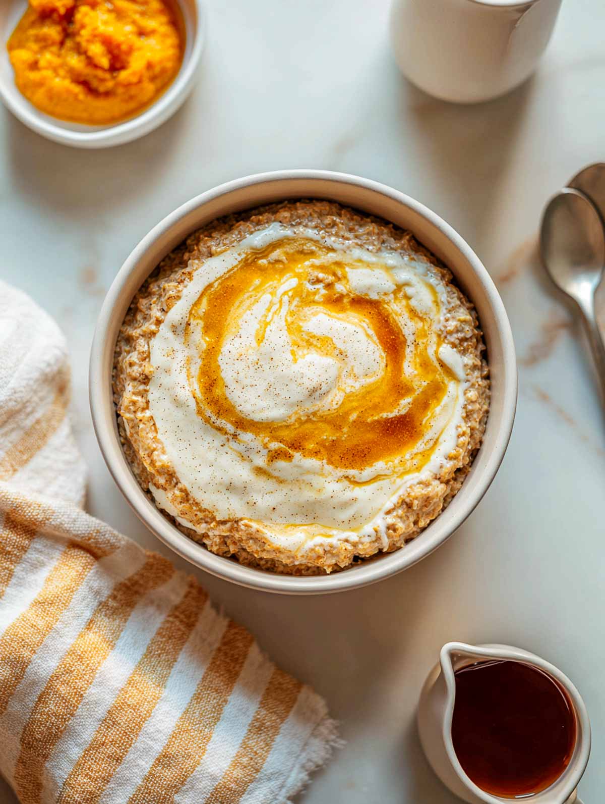 Warm pumpkin oatmeal bowl with creamy cheesecake swirl and maple drizzle.