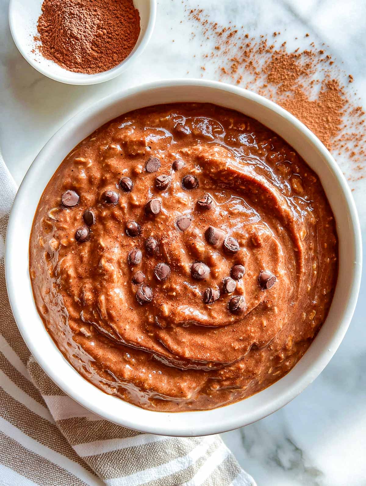 mocha brownie oatmeal with a soft cocoa swirl on marble surface.