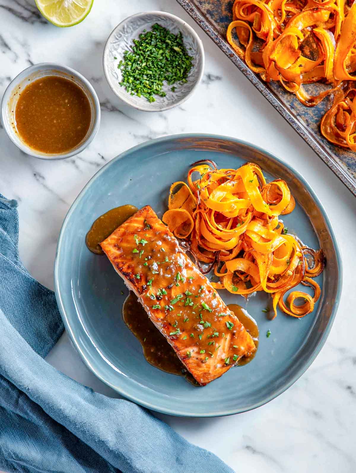 Brown sugar mustard glazed salmon served with roasted sweet potato ribbons on plate.