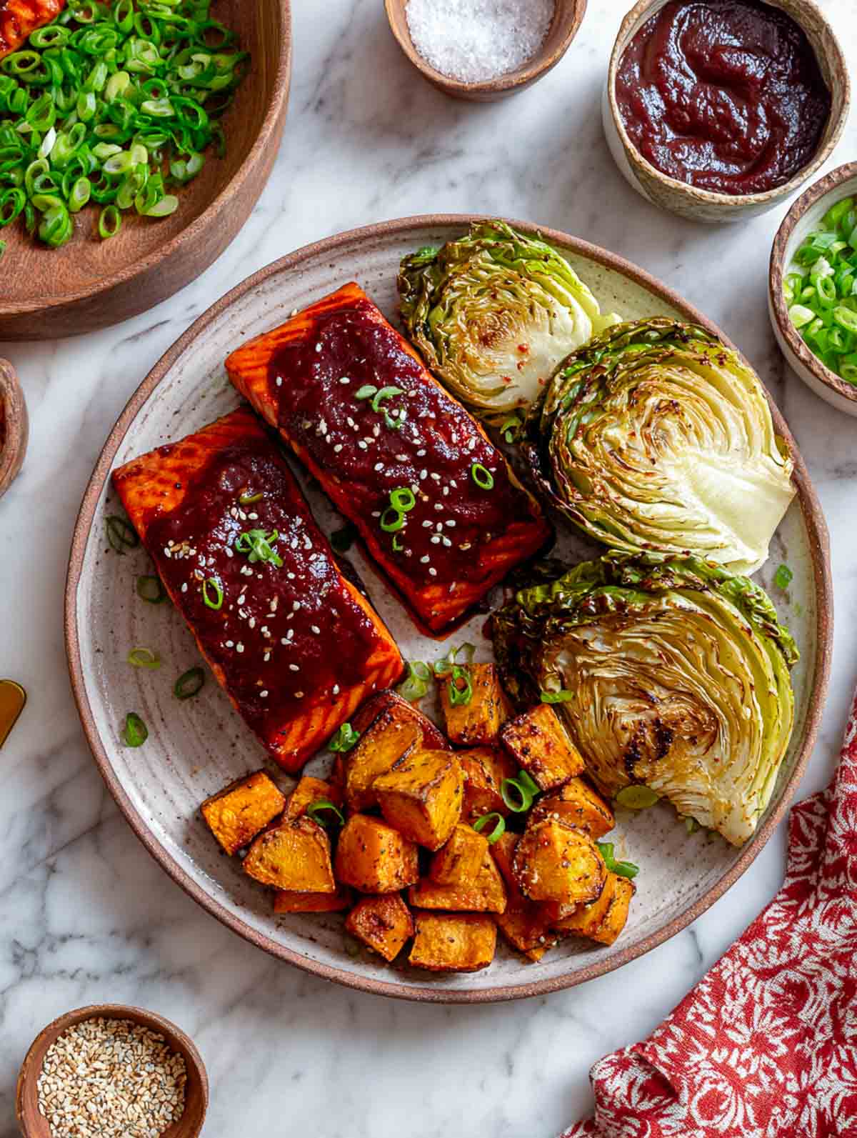 Gochujang-glazed salmon fillets served with roasted cabbage steaks and sweet potato chunks.
