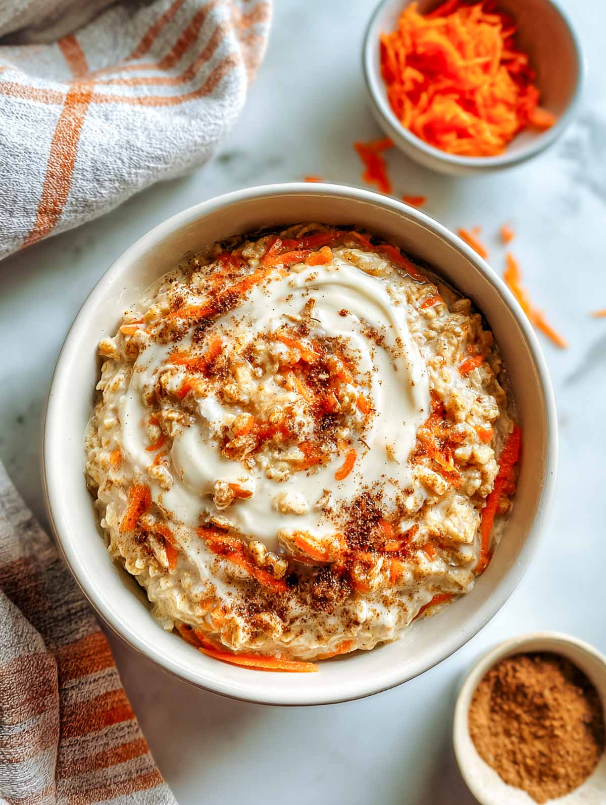 Creamy carrot cake oatmeal with coconut yogurt swirl and cinnamon dusting.