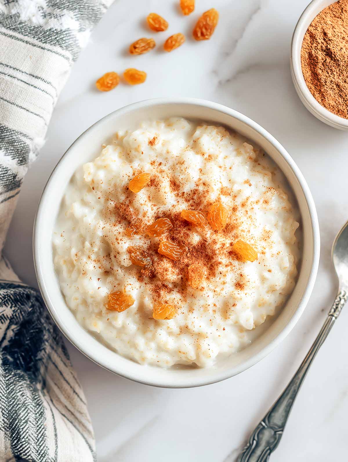Creamy rice and oatmeal pudding topped with golden raisins and cinnamon.