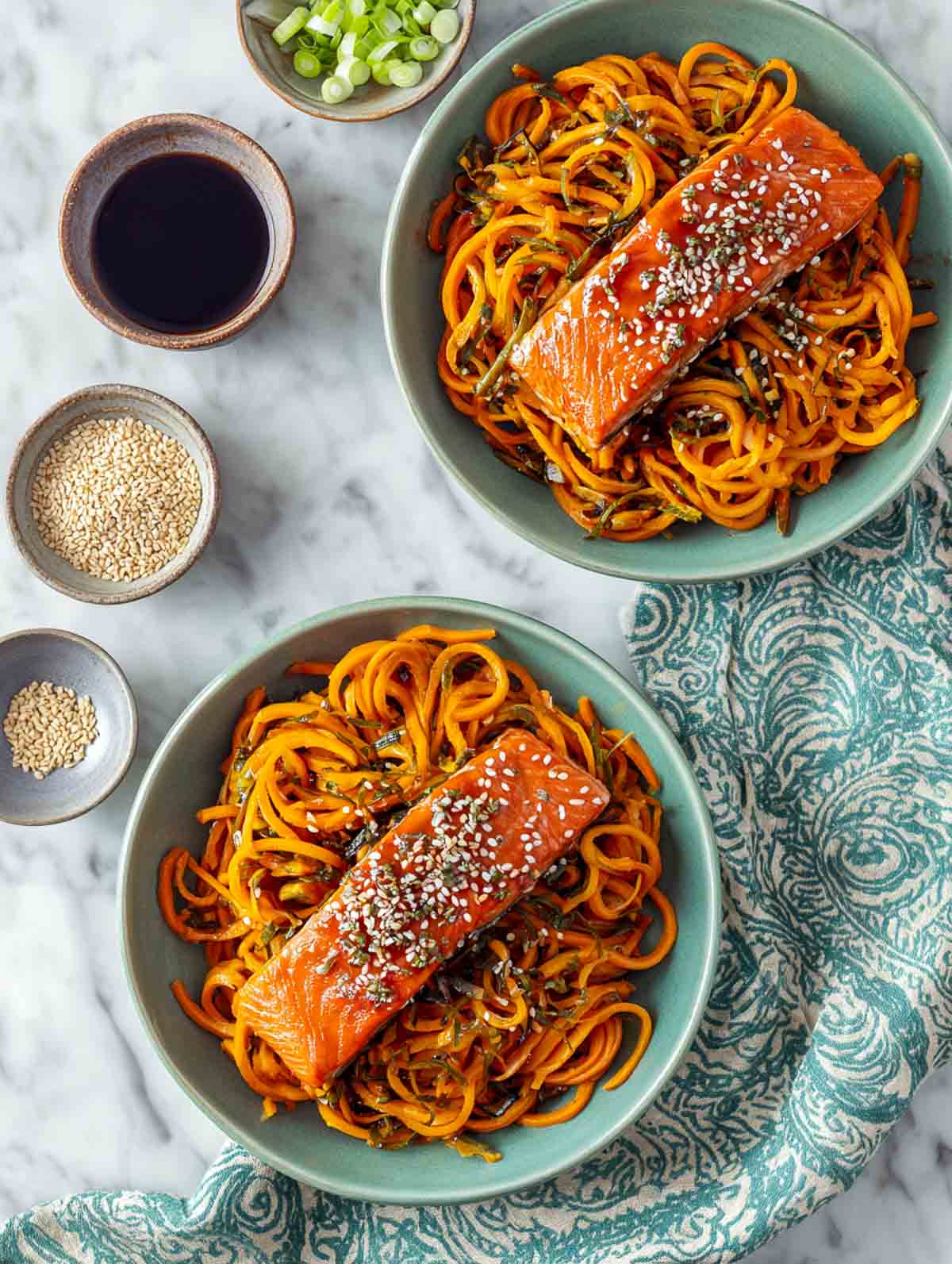 Sesame-ginger salmon served over seasoned sweet potato noodles in a sage bowl.
