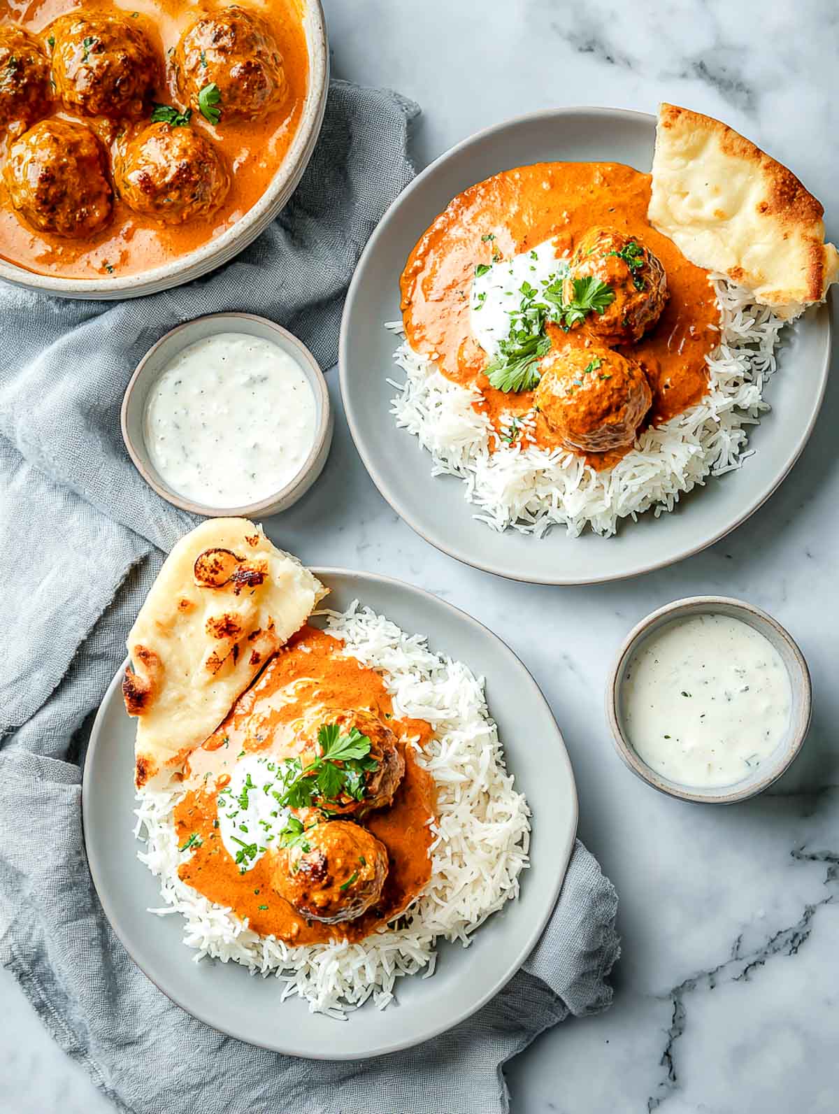 Plated Indian lamb meatballs with rice, naan, and yogurt sauce.