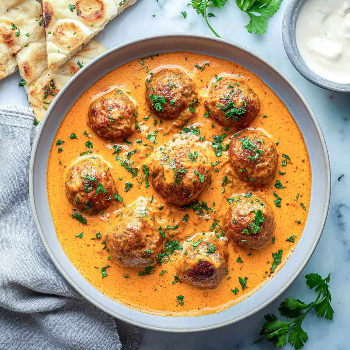 Top view of lamb meatballs simmered in creamy Indian curry sauce.