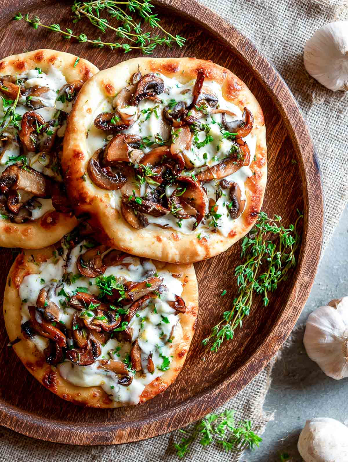 Mini mushroom flatbreads topped with garlic cream sauce and sautéed mushrooms.