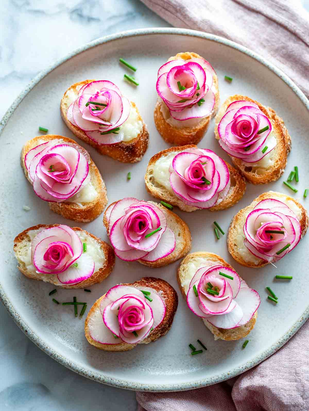 Radish rose canapés with lemon butter on toasted baguette slices.
