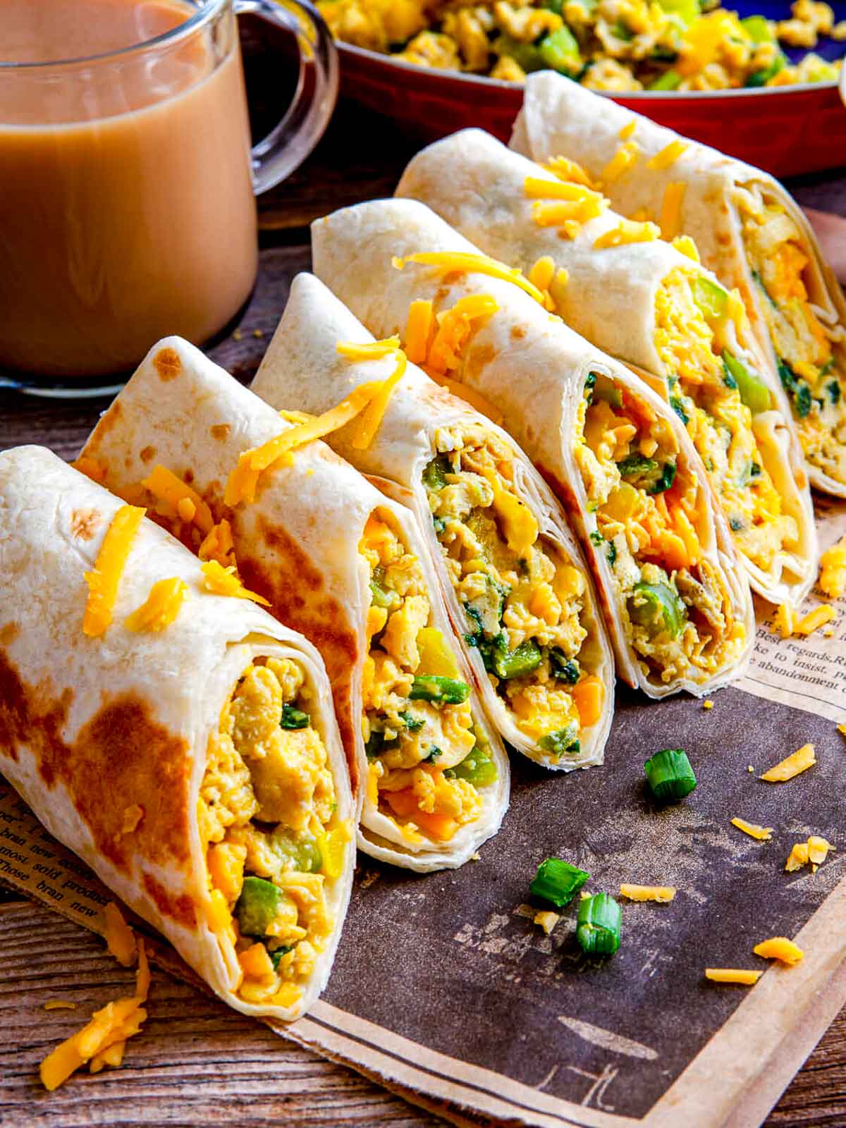 Sliced breakfast burritos showing fluffy eggs, bell peppers, and melted cheese.