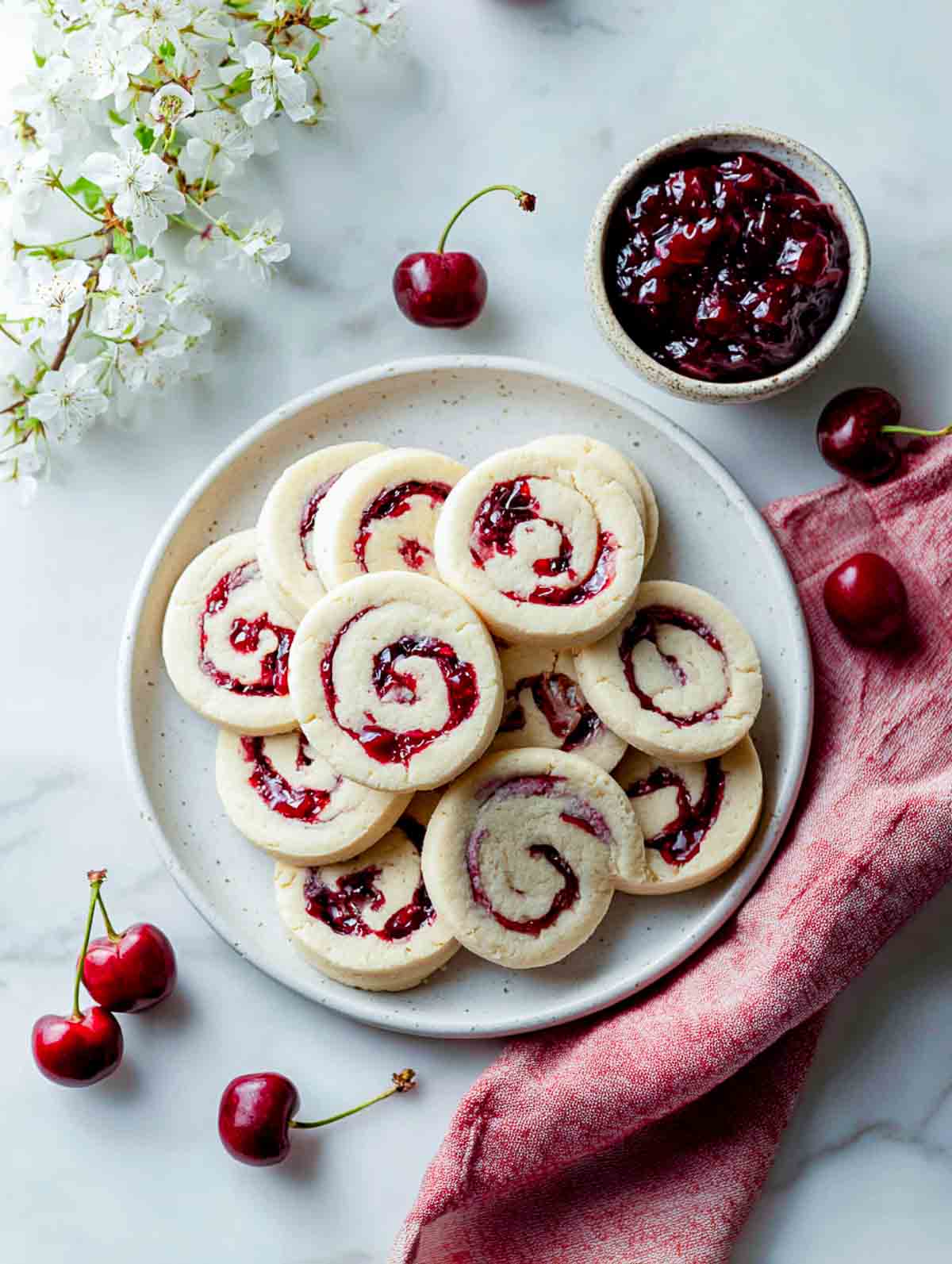 Cherry cheesecake pinwheel cookies with cream cheese dough and cherry swirl.