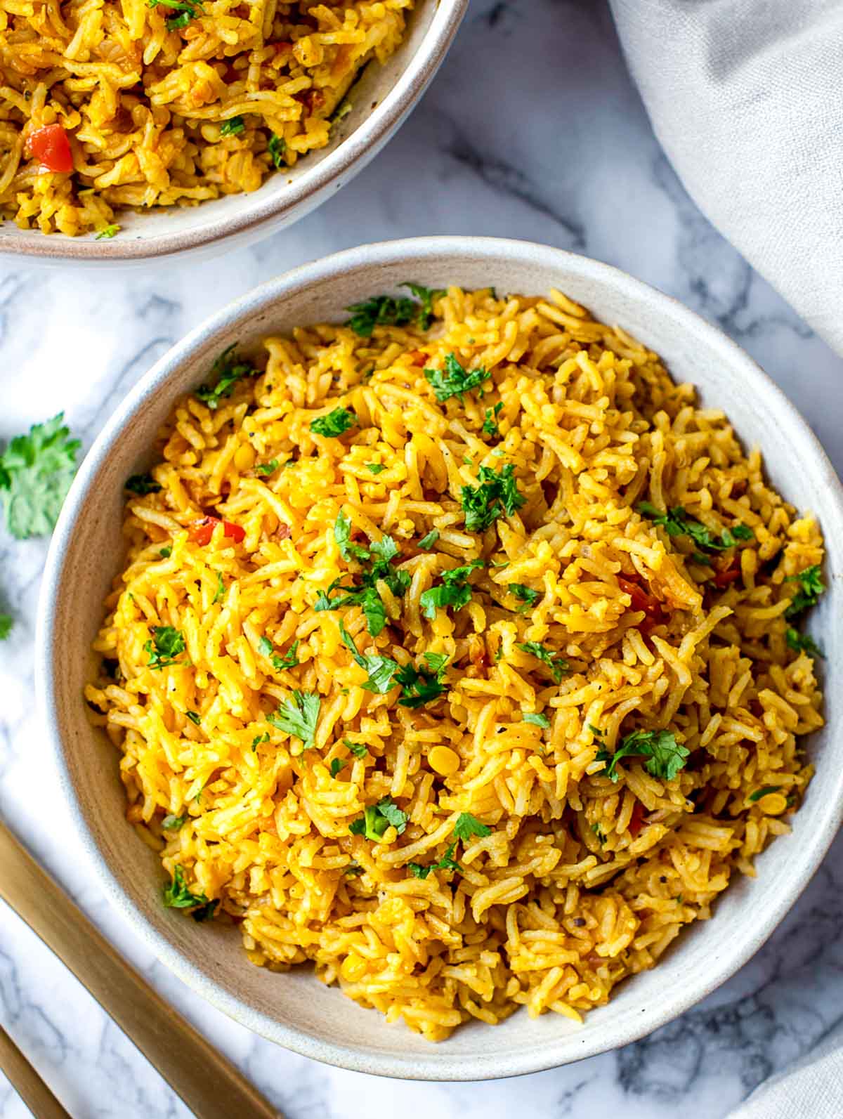 Bowl of golden curry lentil rice with fluffy basmati and cilantro garnish.