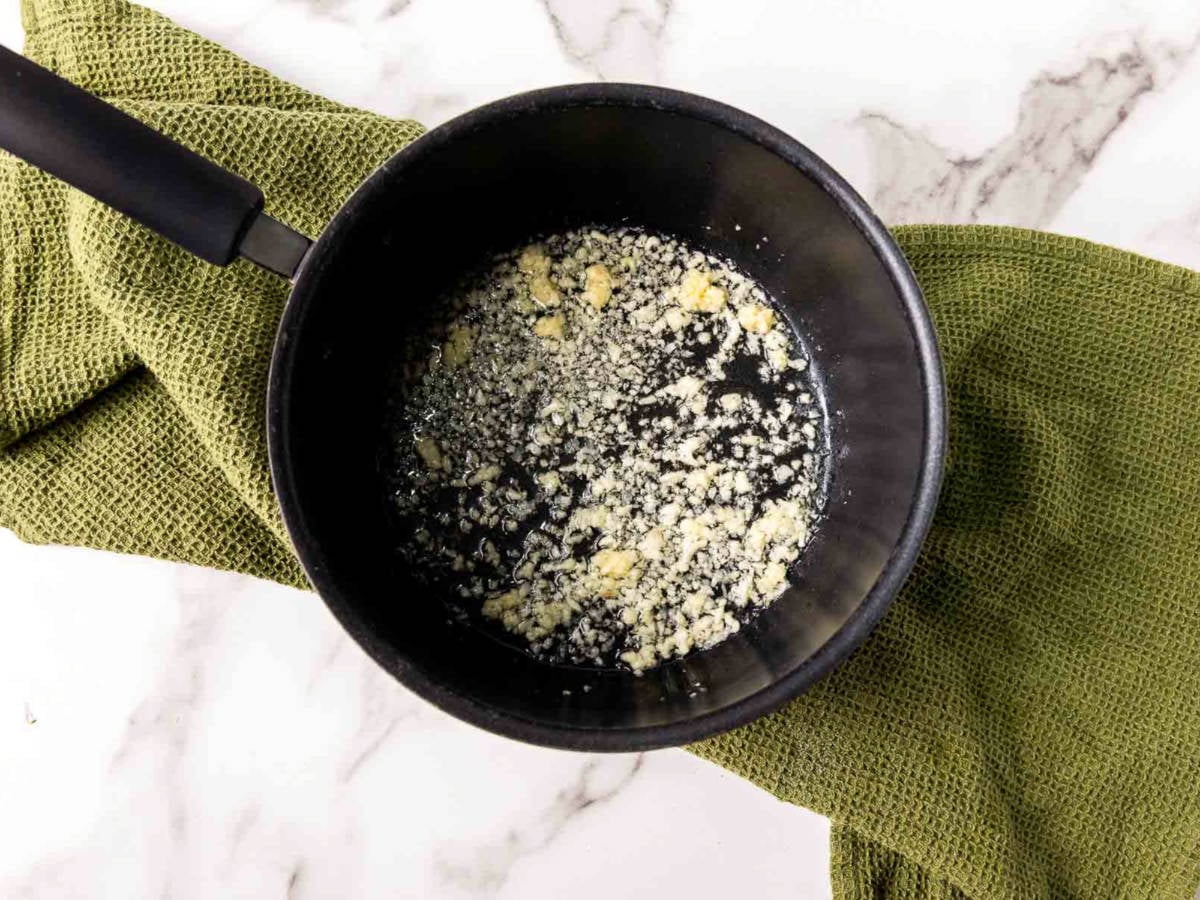 Minced garlic gently sautéing in oil in a small saucepan.