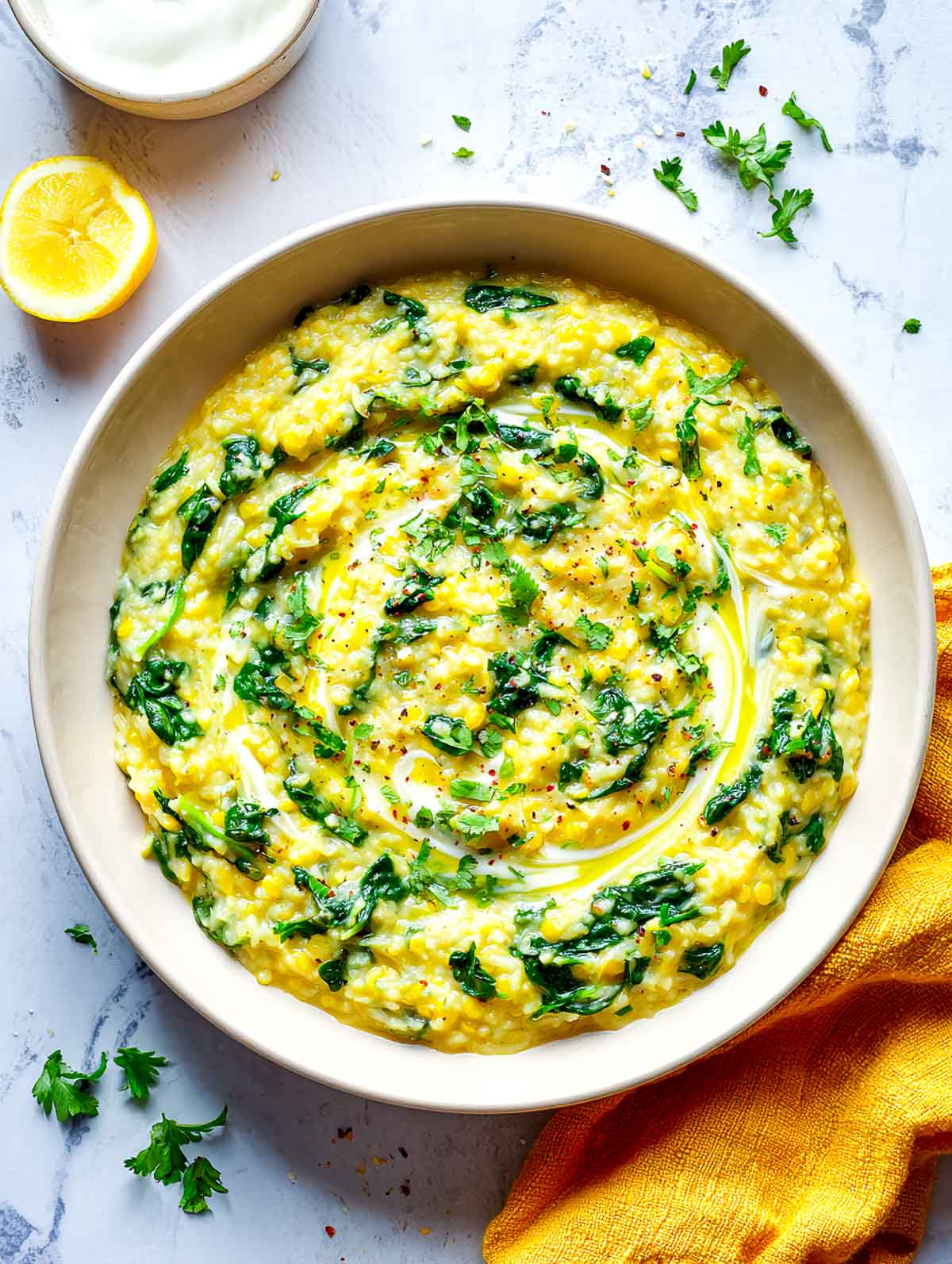 Spinach dal rice cooker khichdi with ghee swirl and herbs in a shallow bowl.
