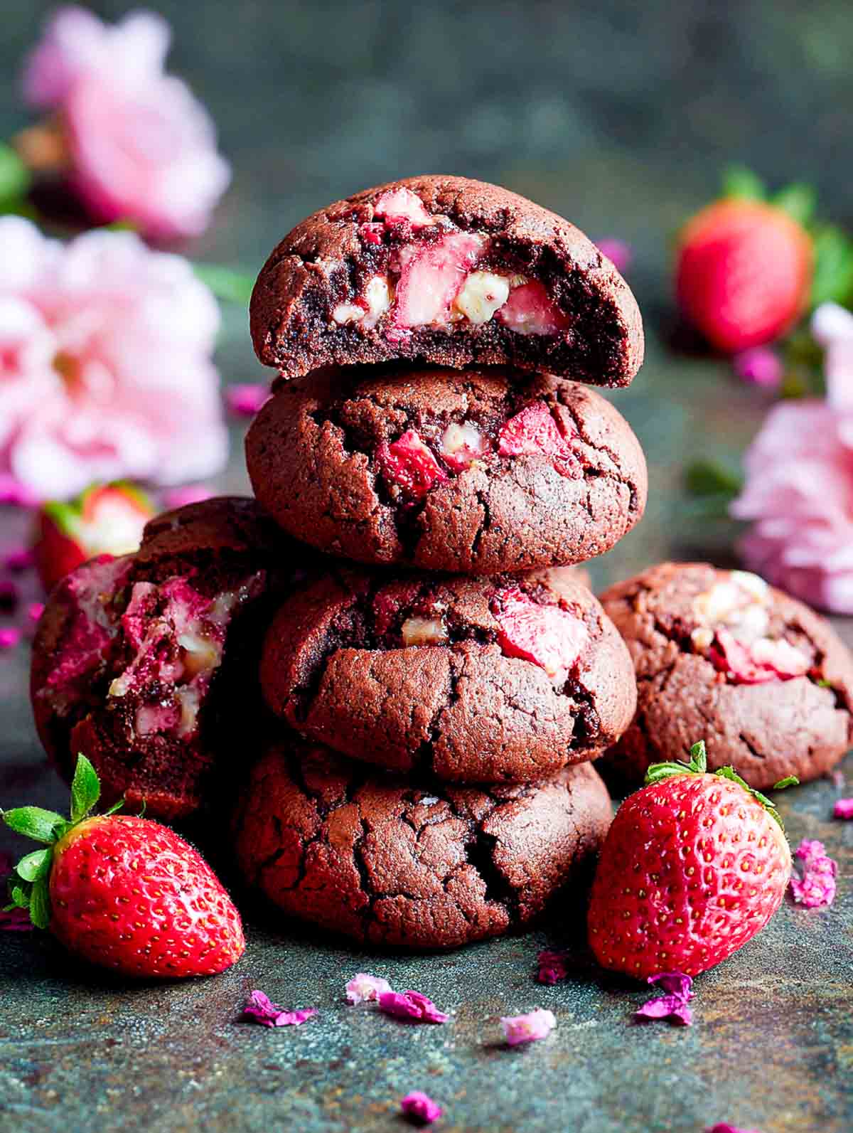 Strawberry brownie cookies with cracked tops and fudgy centers on a plate.