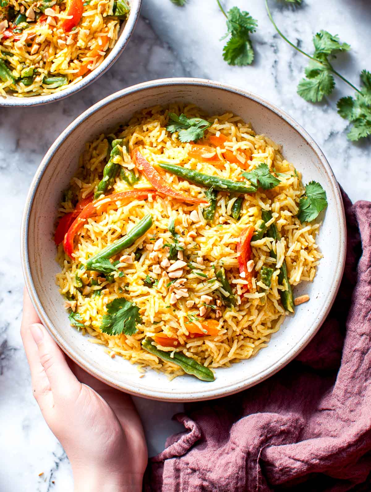 Thai curry rice cooker vegetable rice topped with crushed peanuts and cilantro in a bowl.