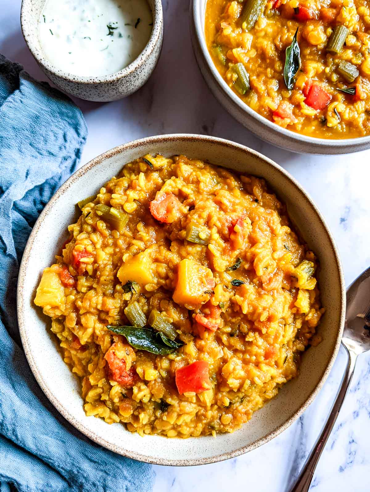 Rice cooker sambar rice with lentils and vegetables in a thick, spoonable texture.