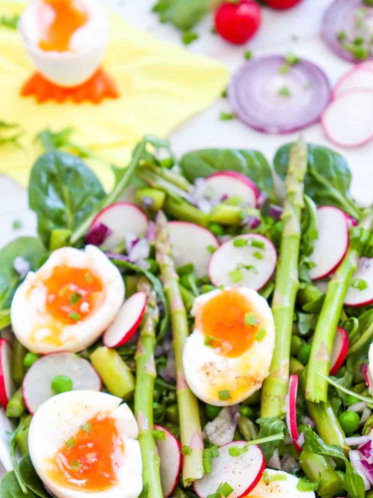Side view of asparagus salad with soft boiled eggs on the top.