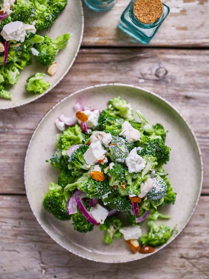 Broccoli salad with feta, red onion, and sliced almonds on a plate.