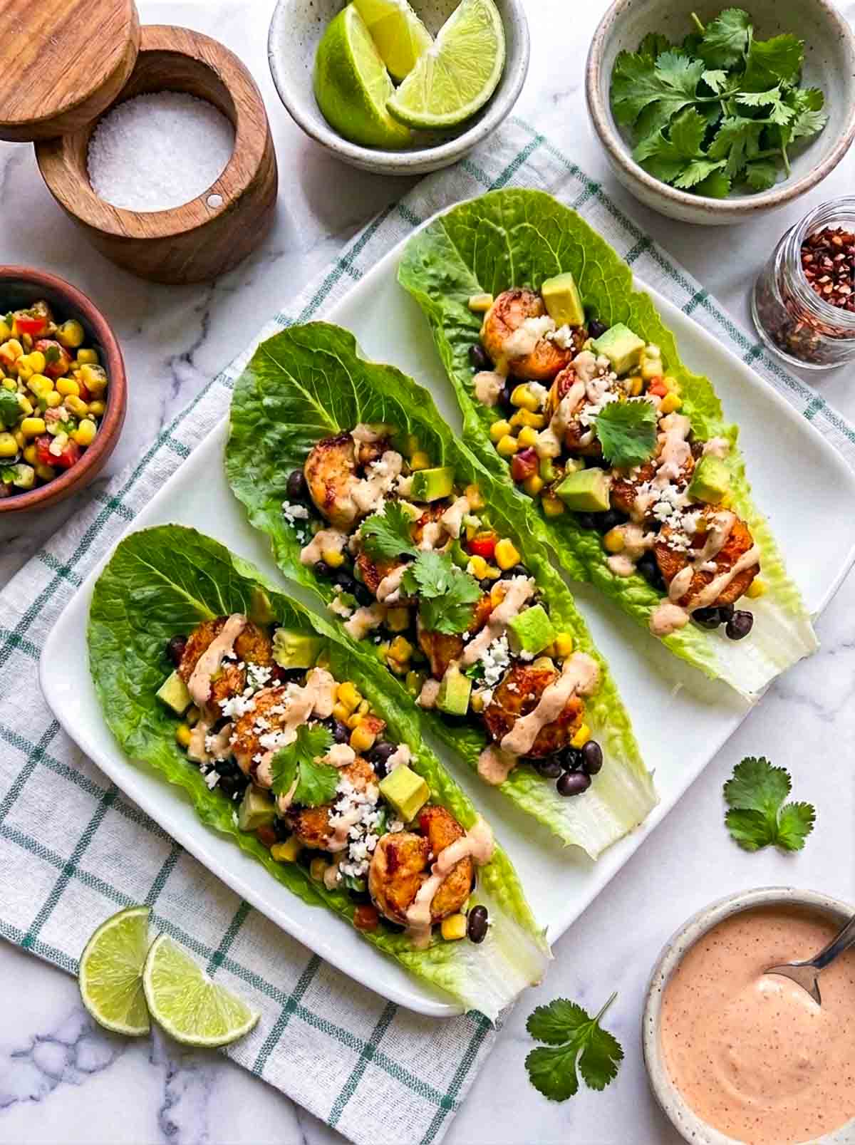Chipotle shrimp lettuce wraps placed on a rectangular serving plate.