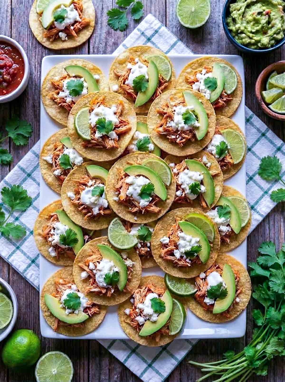 A stack of chicken tinga tostada bites placed on a serving plate for a party.