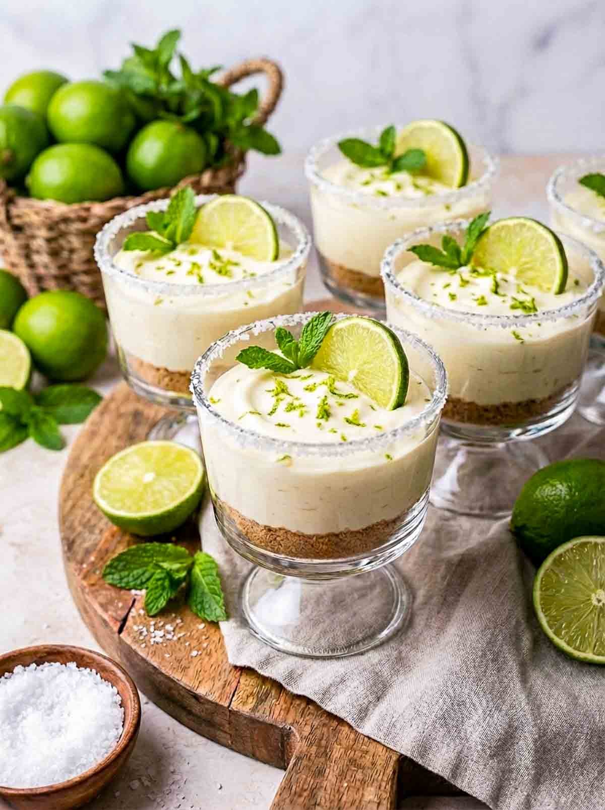 Side view of margarita lime cheesecake cups with a lime basket in the background.