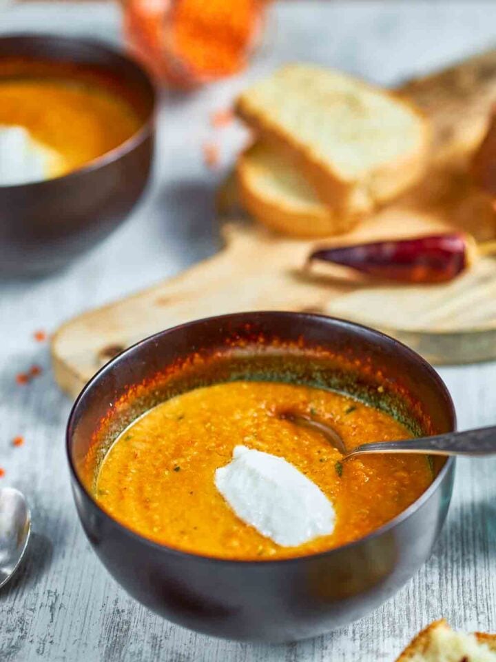 Bowl of carrot lentil soup with spoon