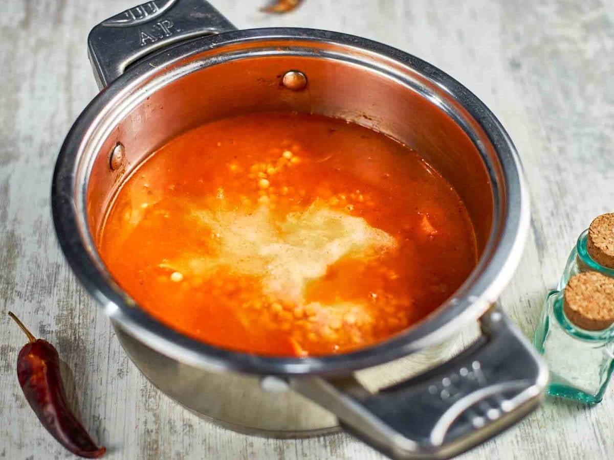 The soup simmers as the lentils soften and blend with the rich, spiced bro