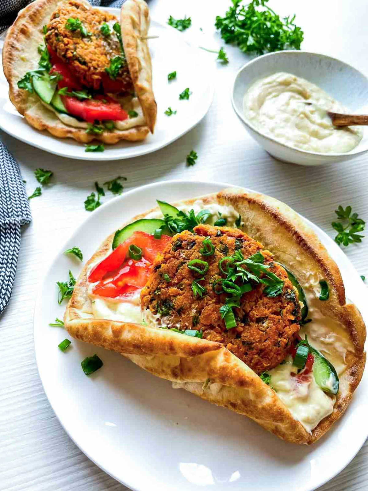 Two falafel pitas with creamy dip on side