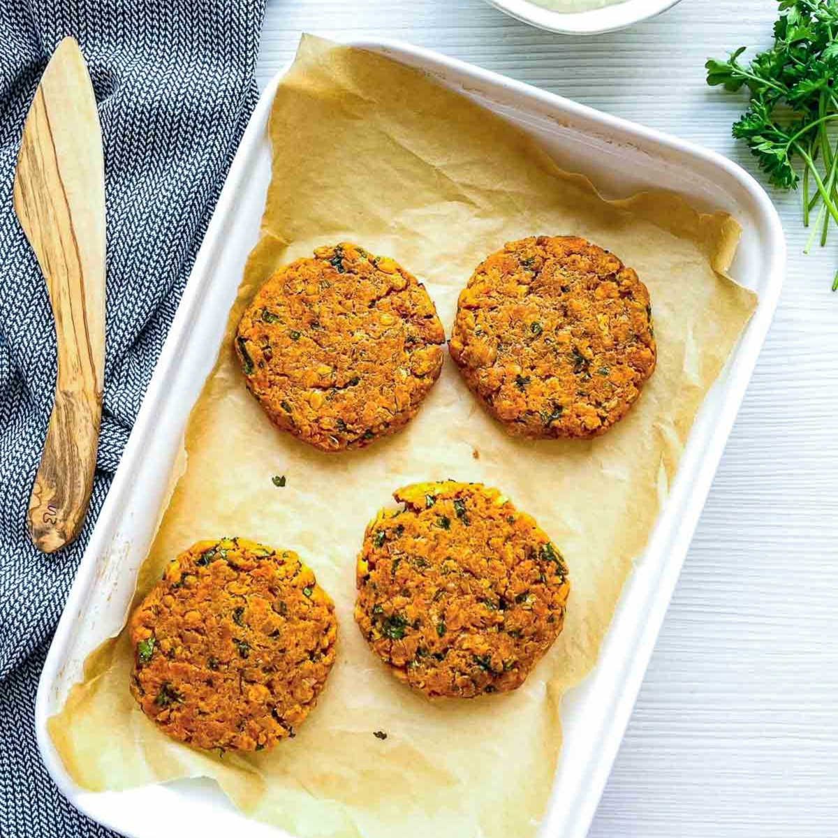Raw falafel patties on parchment-lined tray