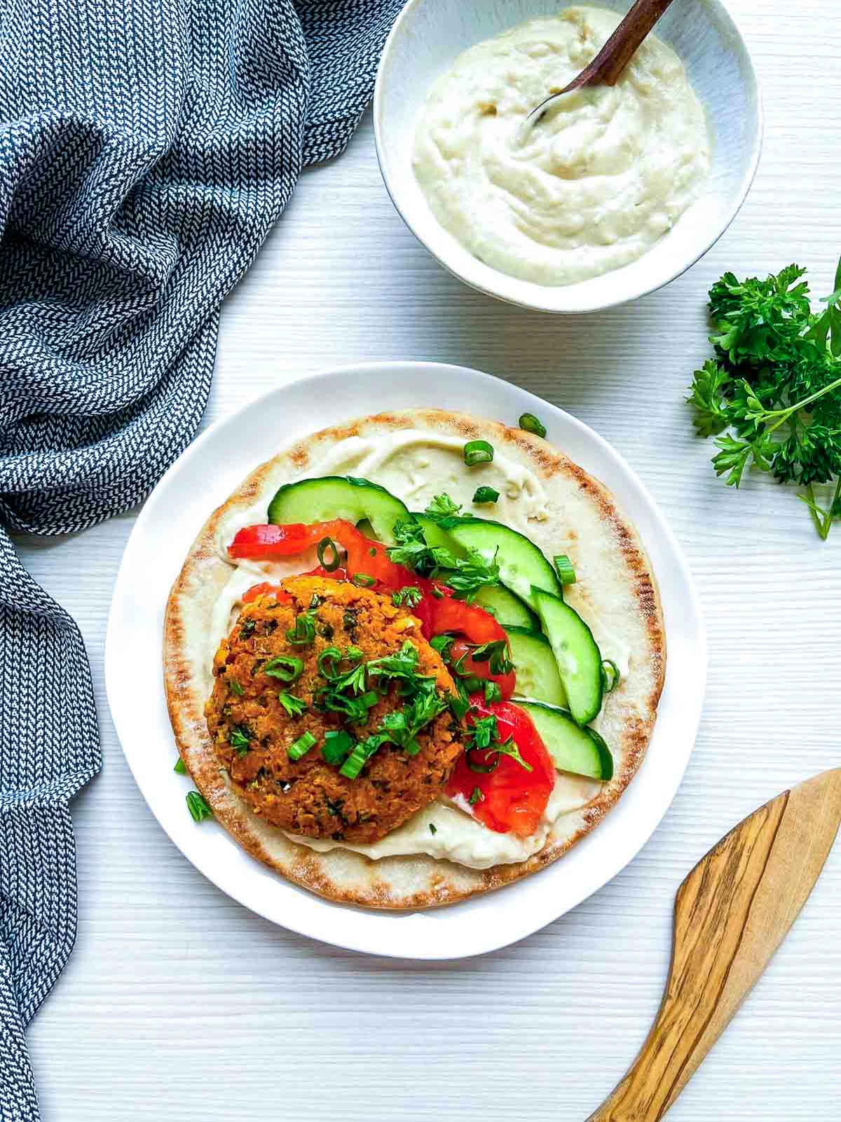 Falafel pita with vegetables and sauce on plate