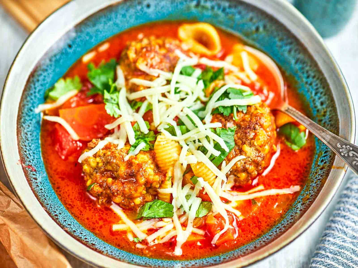 Italian meatball soup with pasta and cheese.